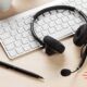 A keyboard and a headset symbolizing a call center setup, focusing on effective outbound calling strategies for better customer engagement.