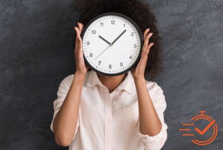 A woman covers her face with a clock, representing time management training