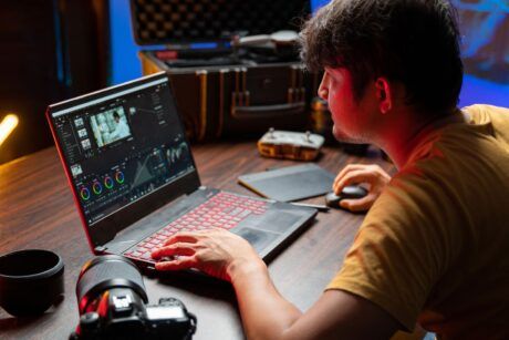 a man focused on his laptop, seated at a desk, engaged in a camtasia studio tutorial session