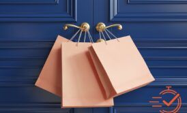 Shopping bags resting against a blue door with a golden handle, showcasing a vibrant retail sales vibe.