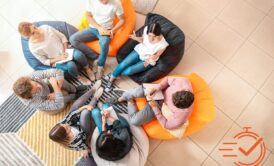 A circle of individuals on bean bags, actively participating in a collaborative training session.