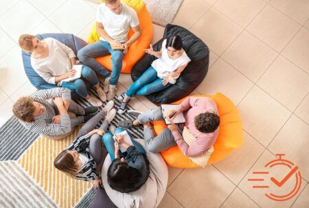 A circle of individuals on bean bags, actively participating in a collaborative training session.