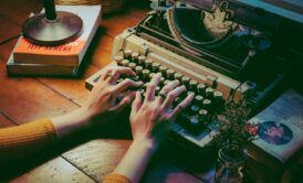 a person engaged in typing on an old typewriter, reflecting on their memoir writing course experience