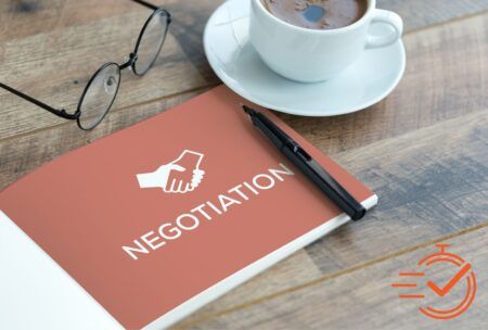 A coffee cup and pen on a desk, illustrating the concept of online negotiation courses.