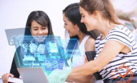 Three women collaborating over a laptop, exploring AI in the workplace together.