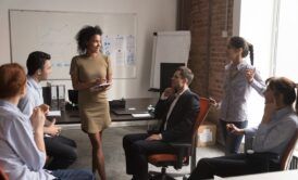 a diverse group of professionals engaged in a coaching business training meeting in a modern office setting