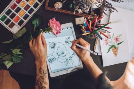 an artist is engaged in drawing a flower on a tablet, utilizing Procreate Dreams to express her artistic vision