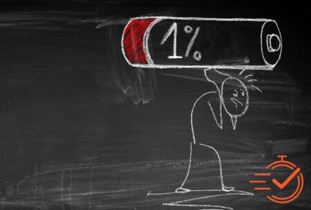 Chalk drawing of a stick figure carrying a large battery icon displaying 1% charge on a blackboard while overcoming burnout.