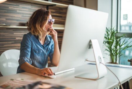 a woman in glasses works at her desk, engaged with her computer, during a 2d whiteboard animation for beginners class