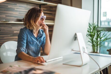 a woman in glasses works at her desk, engaged with her computer, during a 2d whiteboard animation for beginners class