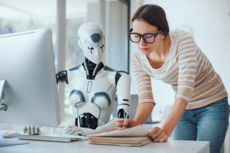 a woman engaged in writing, accompanied by a robot, illustrating the role accounting ai practices