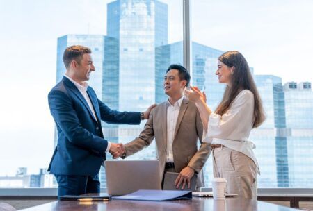 two business individuals shaking hands in an office, illustrating the art of persuasion in professional relationships