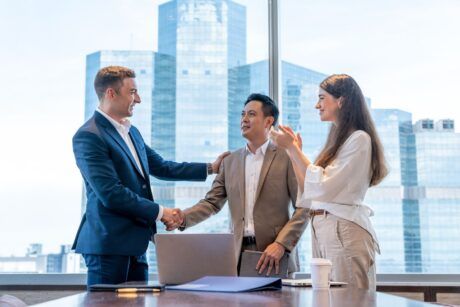 two business individuals shaking hands in an office, illustrating the art of persuasion in professional relationships